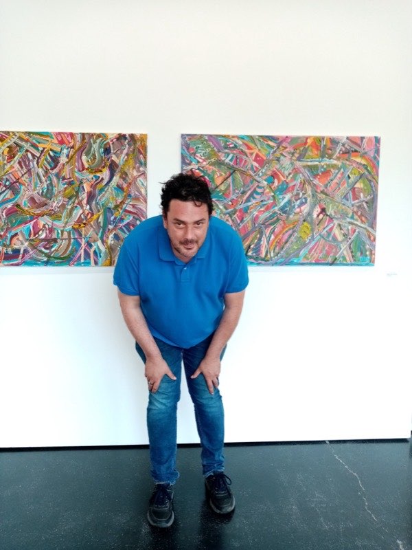 David De Henau with his paintings